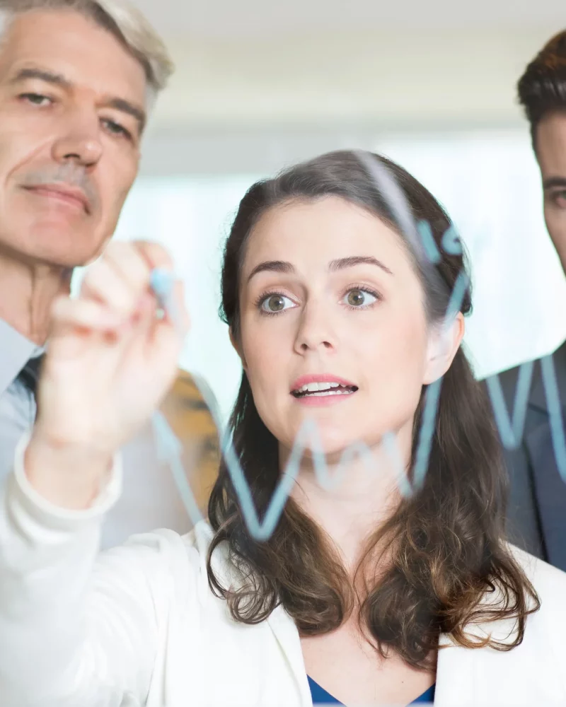 young-businesswoman-drawing-graph-with-colleagues